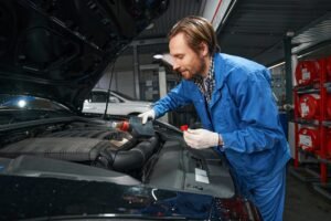 driver with the hood open trying to figure out why the car won't start in a Santa Cruz driveway
